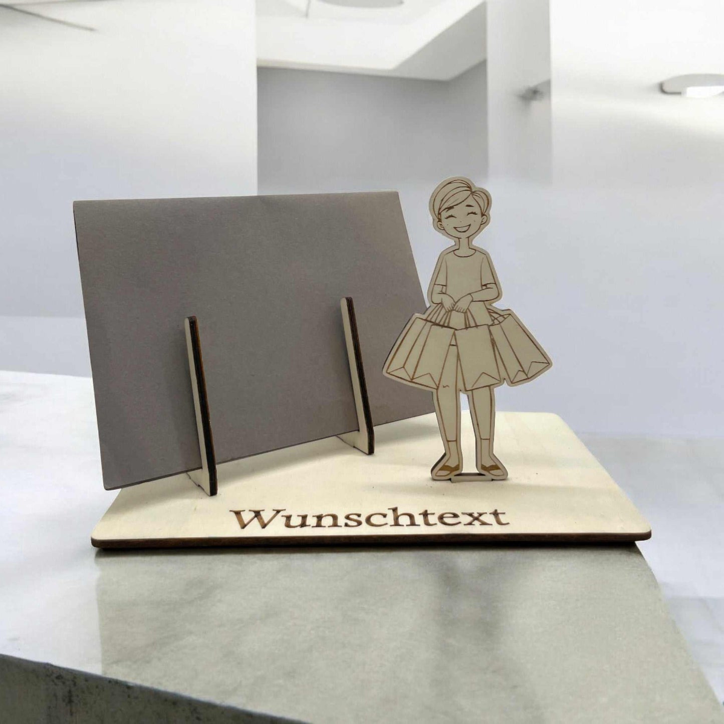 Gutschein verpacken mit Shopping-Motiv – Holzfigur mit Einkaufstaschen und Wunschtext