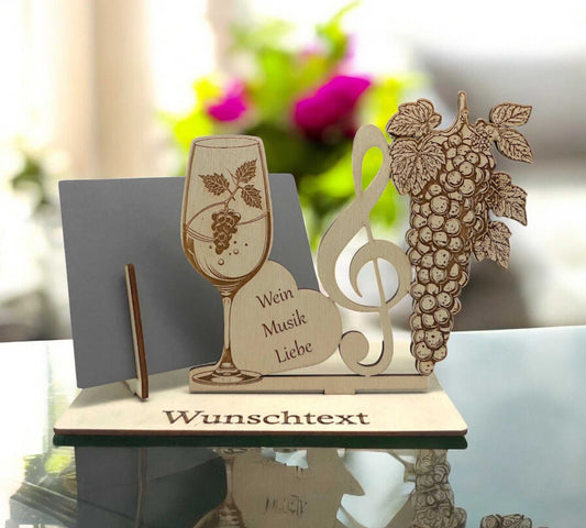 Gutschein verpacken mit Weinglas, Notenschlüssel und Gravur „Wein, Musik, Liebe“