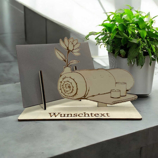 Gutschein verpacken mit Wellness-Motiv – Handtuchrolle, Kerzen und Blume aus Holz